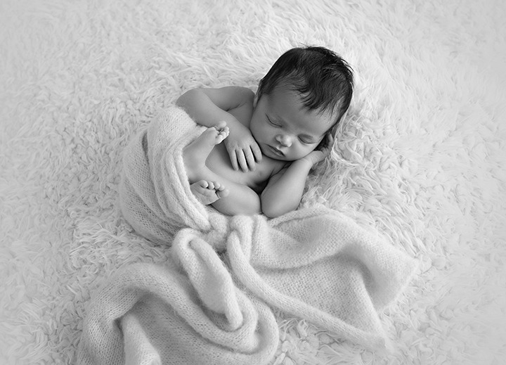 "adorable newborn baby peacefully posed and sleeping"